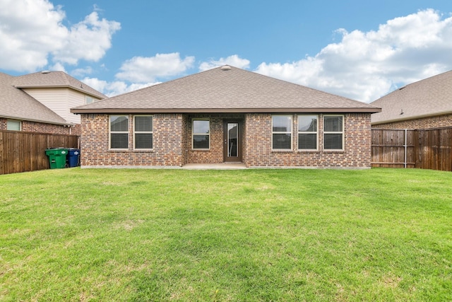 back of house with brick siding, a fenced backyard, and roof with shingles