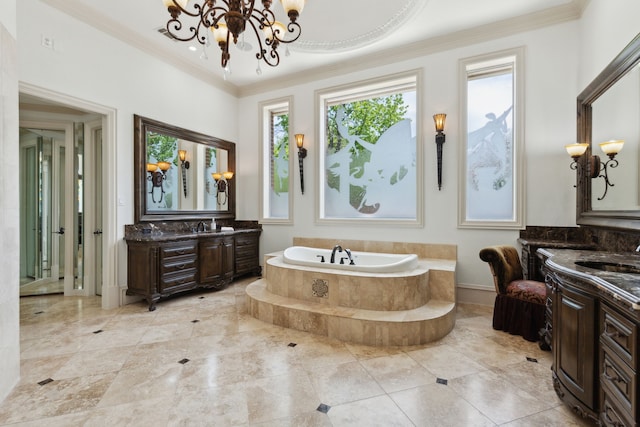 bathroom featuring a sink, a garden tub, a notable chandelier, two vanities, and ornamental molding