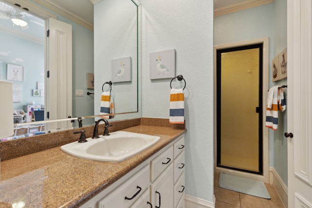 bathroom featuring a stall shower, vanity, crown molding, and tile patterned flooring