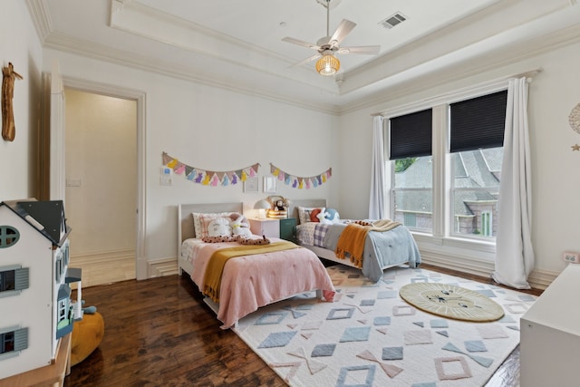 bedroom featuring crown molding, wood finished floors, and a raised ceiling