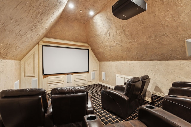 carpeted cinema room with baseboards, lofted ceiling, and a textured wall