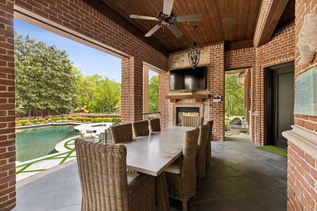 view of patio with a ceiling fan, an outdoor pool, an outdoor brick fireplace, and outdoor dining area