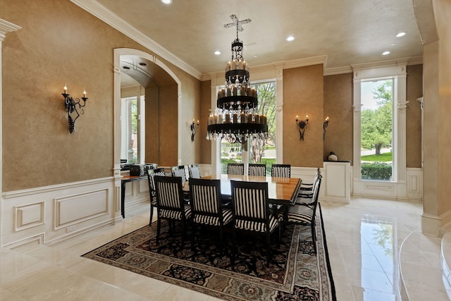 dining space featuring an inviting chandelier, a decorative wall, and a healthy amount of sunlight