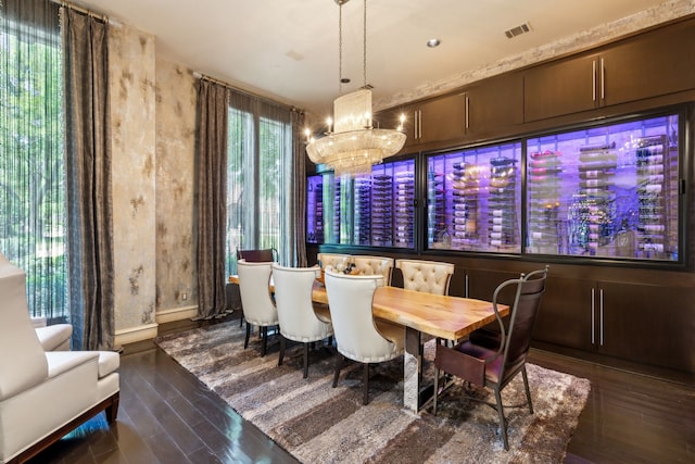 dining room featuring wood finished floors, visible vents, and a notable chandelier