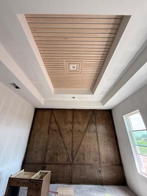 interior details featuring a raised ceiling and wood ceiling