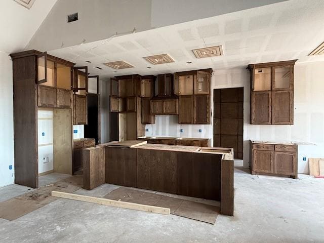 kitchen featuring glass insert cabinets, a spacious island, and visible vents