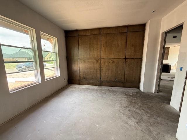 unfurnished bedroom with unfinished concrete flooring