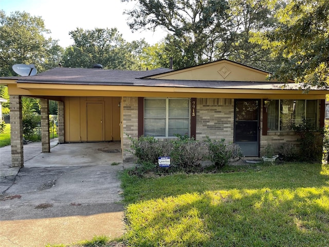 view of front facade with driveway, board and batten siding, an attached carport, a front lawn, and brick siding