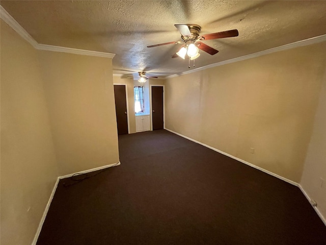 empty room with ceiling fan, baseboards, dark carpet, a textured ceiling, and crown molding