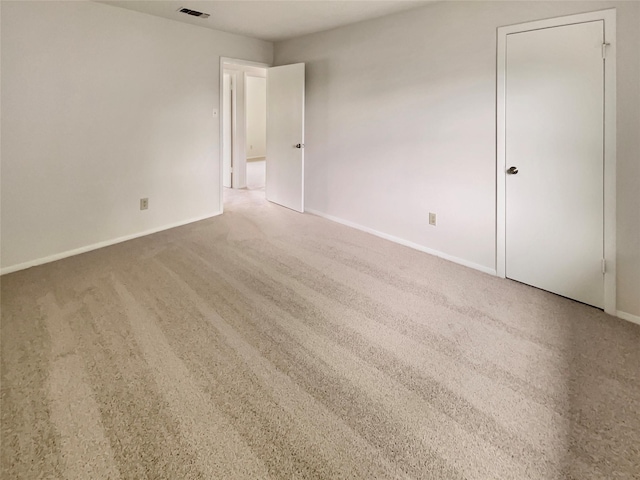 empty room featuring baseboards, carpet floors, and visible vents