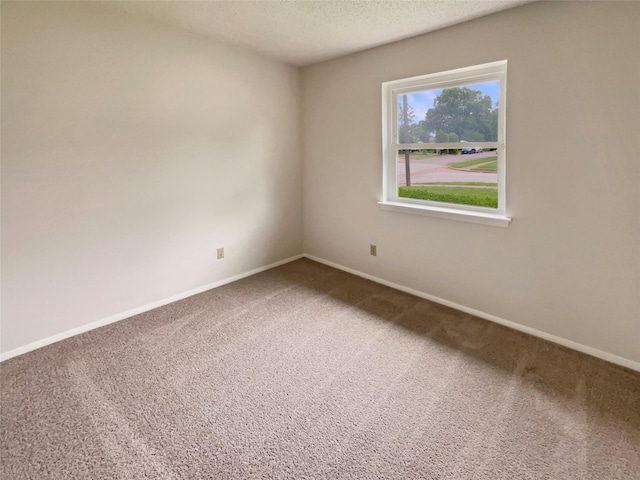 unfurnished room with carpet floors, a textured ceiling, and baseboards