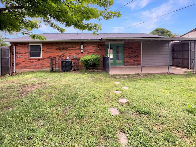 back of property with fence, brick siding, cooling unit, a patio area, and a yard