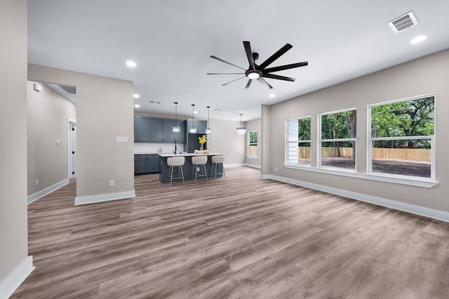 unfurnished living room featuring visible vents, ceiling fan, and baseboards