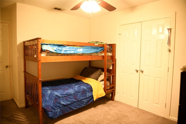 carpeted bedroom with ceiling fan, a closet, and visible vents