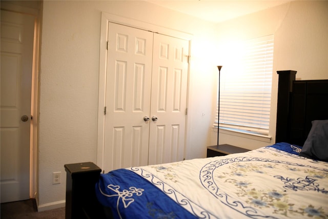 bedroom featuring a closet, baseboards, and dark carpet