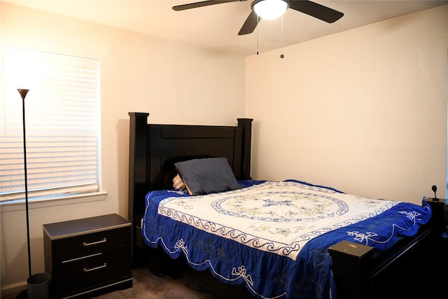 bedroom with a ceiling fan and dark carpet