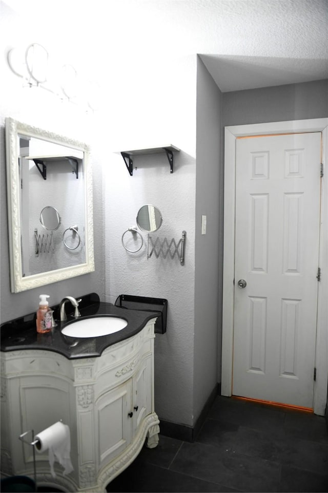 bathroom with baseboards, tile patterned flooring, and vanity