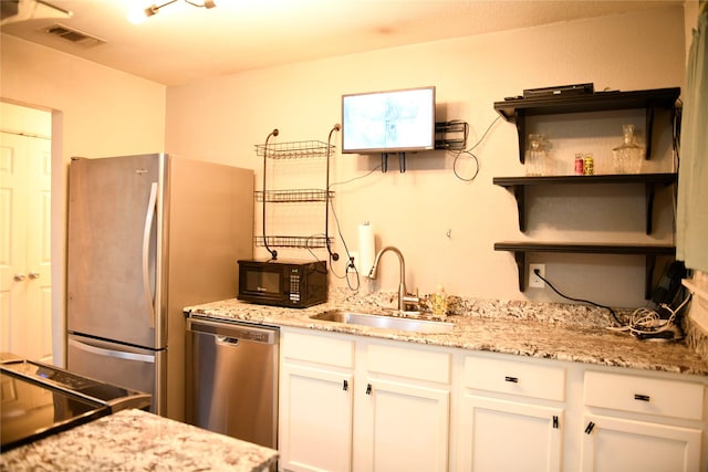 kitchen featuring a sink, open shelves, white cabinetry, and appliances with stainless steel finishes