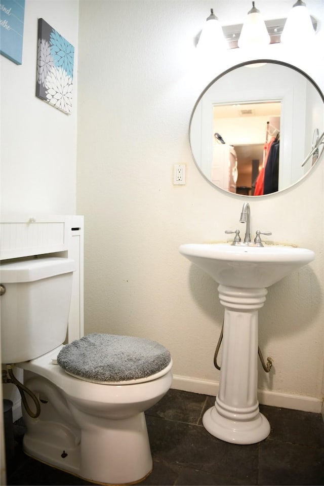bathroom featuring a sink, toilet, and baseboards