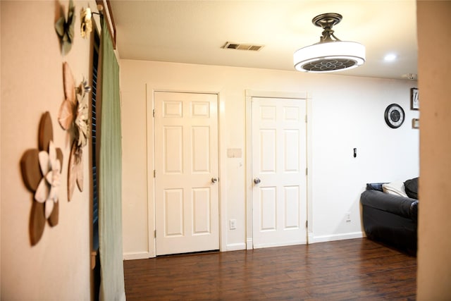 entryway featuring baseboards, visible vents, and dark wood-type flooring