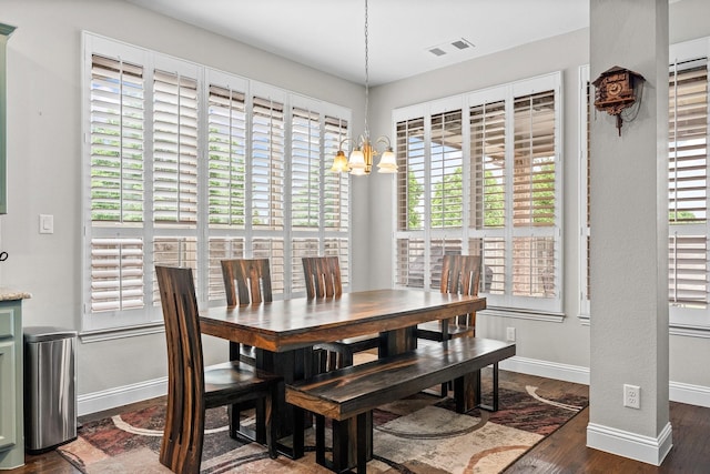 dining area featuring an inviting chandelier, baseboards, wood finished floors, and visible vents