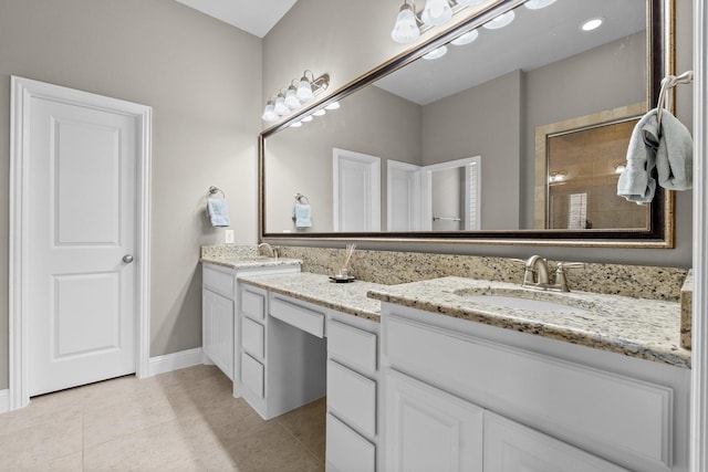 full bath with a sink, baseboards, tile patterned flooring, and double vanity