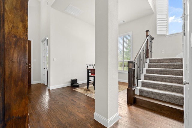 entryway featuring stairway, baseboards, wood finished floors, and visible vents