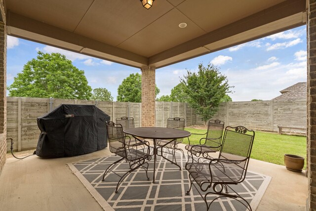 view of patio / terrace with a fenced backyard, outdoor dining space, and a grill