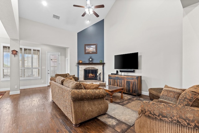 living area featuring ceiling fan, visible vents, high vaulted ceiling, baseboards, and dark wood-style floors
