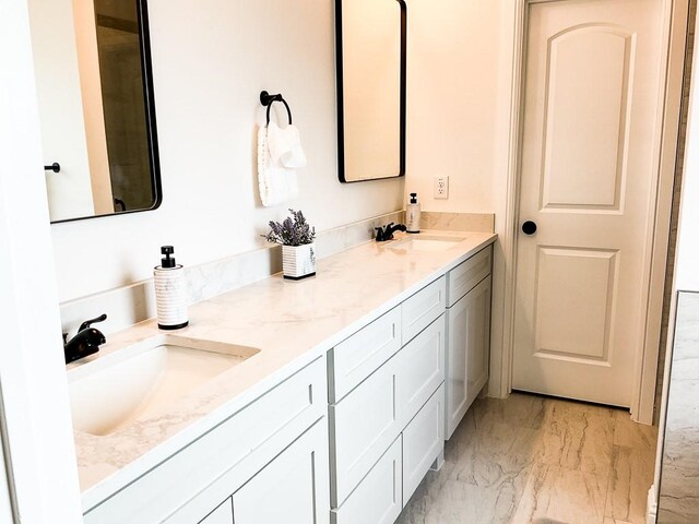 bathroom with double vanity, a sink, and marble finish floor