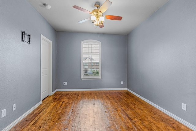 unfurnished room featuring baseboards, ceiling fan, and wood finished floors