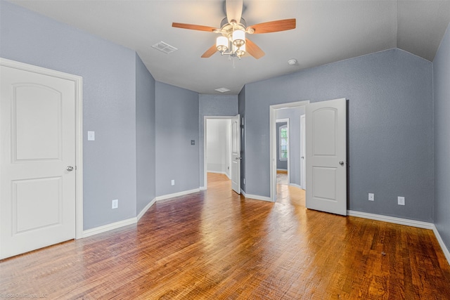 unfurnished bedroom featuring baseboards, visible vents, a ceiling fan, and wood finished floors