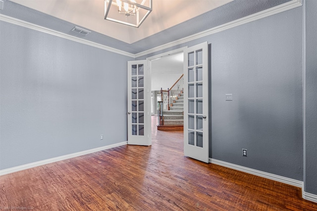 empty room featuring stairs, french doors, wood finished floors, visible vents, and an inviting chandelier