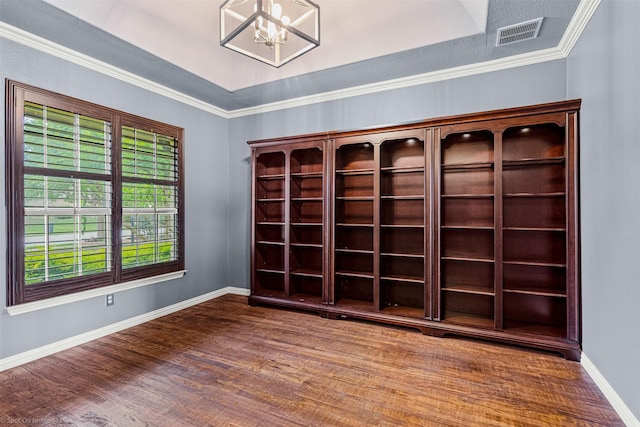 spare room featuring baseboards, a notable chandelier, visible vents, and wood finished floors