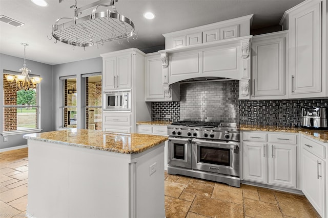 794 Amherst Dr, Rockwall, TX 75087 - kitchen featuring appliances with stainless steel finishes, a kitchen island, stone tile floors, decorative backsplash, and recessed lighting