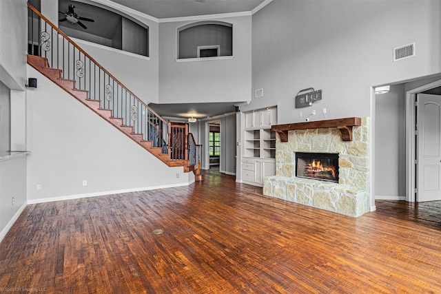 unfurnished living room with visible vents, a towering ceiling, and stairs