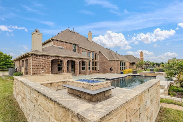 pool featuring a patio, an in ground hot tub, and fence