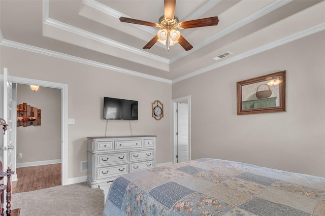 bedroom with visible vents, a raised ceiling, a ceiling fan, and ornamental molding