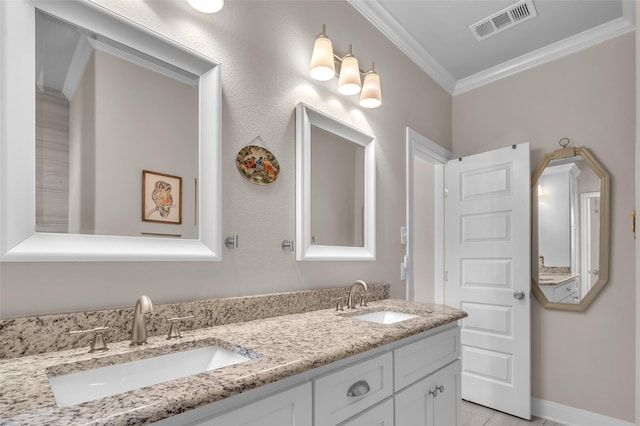 bathroom with double vanity, visible vents, crown molding, and a sink