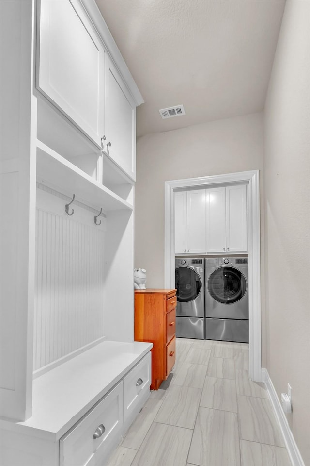 mudroom featuring visible vents and washer and clothes dryer