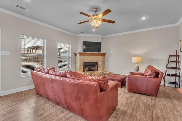 living area featuring a ceiling fan, visible vents, baseboards, and light wood-style floors
