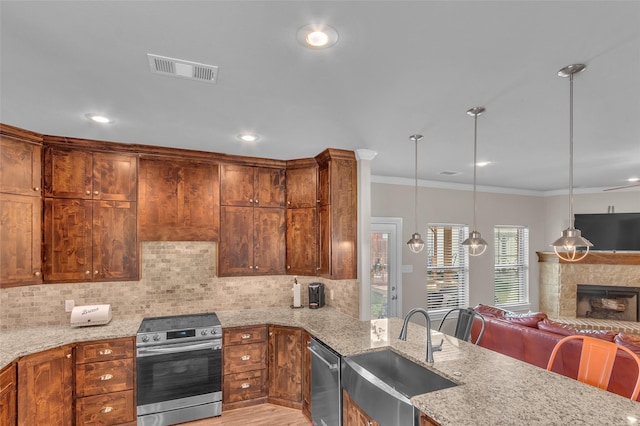 kitchen with decorative backsplash, stainless steel appliances, a sink, visible vents, and open floor plan