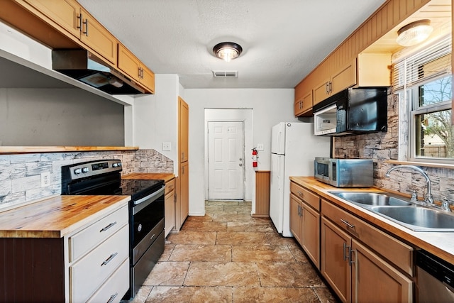 kitchen with a sink, stainless steel appliances, visible vents, backsplash, and butcher block counters