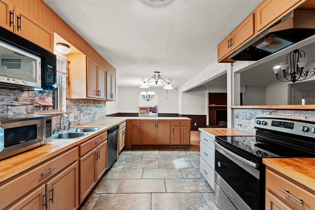 kitchen with a sink, a chandelier, stainless steel appliances, backsplash, and butcher block counters