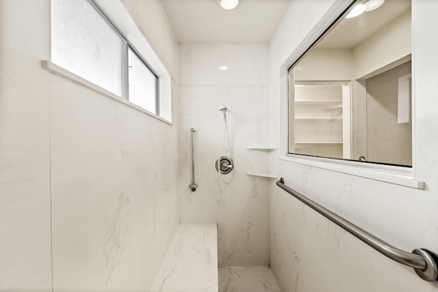 bathroom featuring a marble finish shower