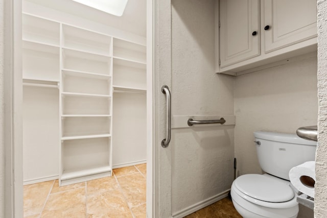 bathroom featuring toilet and tile patterned flooring