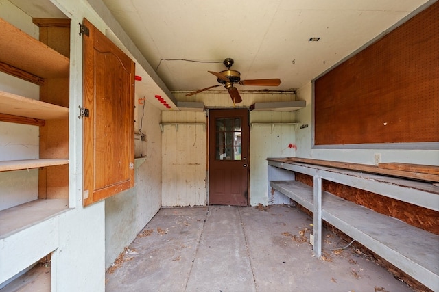 interior space featuring a workshop area, unfinished concrete floors, and ceiling fan