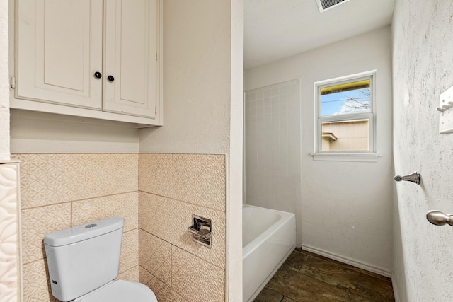 full bath with a shower, toilet, a washtub, and tile walls
