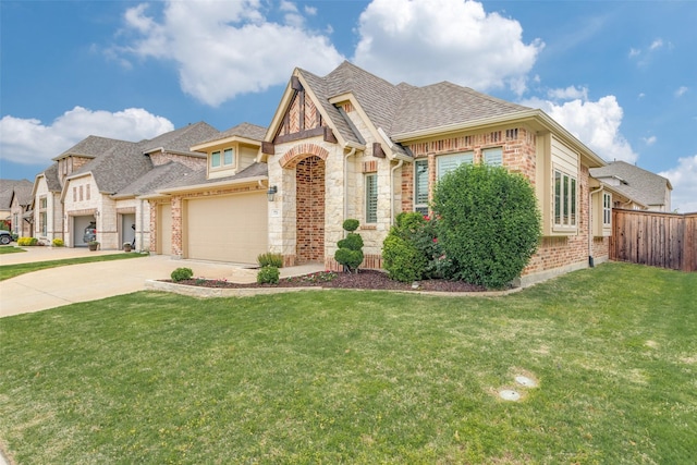 french provincial home with a front lawn, fence, a shingled roof, concrete driveway, and an attached garage