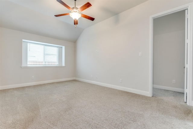 carpeted empty room featuring baseboards, a ceiling fan, and lofted ceiling